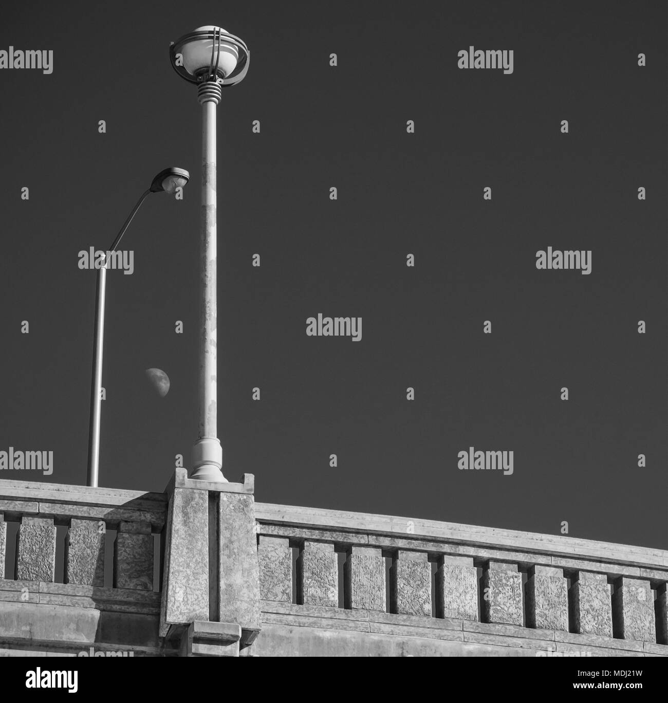 Luna osservata tra la strada e la luce della lampada a ponte post; Winnipeg, Manitoba, Canada Foto Stock