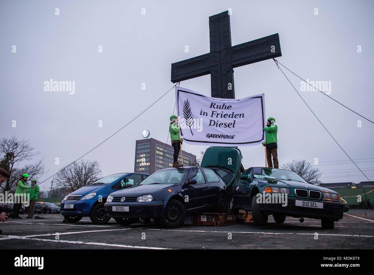 Wolfsburg, Deutschland. Xvi Dec, 2016. Gli attivisti di Greenpeace hold on 16.12.2016 in Wolfsburg (Bassa Sassonia) davanti a una VW amministrazione edificio un banner con le parole "riposare in pace" Diesel. L'organizzazione ambientale ha impostato fino a dieci metri di alta croce e diverse auto rottamate di vari produttori nel parcheggio prima di obiettivo 6 della Volkswagen Plant, alla domanda di un anno dopo il diesel VW scandalo, il rapido ritiro di tutti i produttori di tecnologia diesel. Credito: Philipp von Ditfurth/dpa | in tutto il mondo di utilizzo/dpa/Alamy Live News Foto Stock