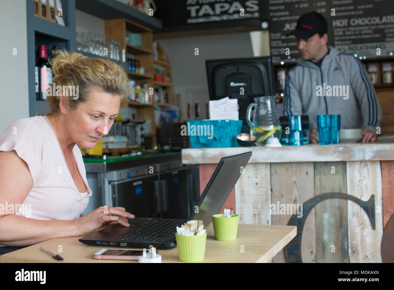 Donna al lavoro su laptop in un coffee shop Foto Stock