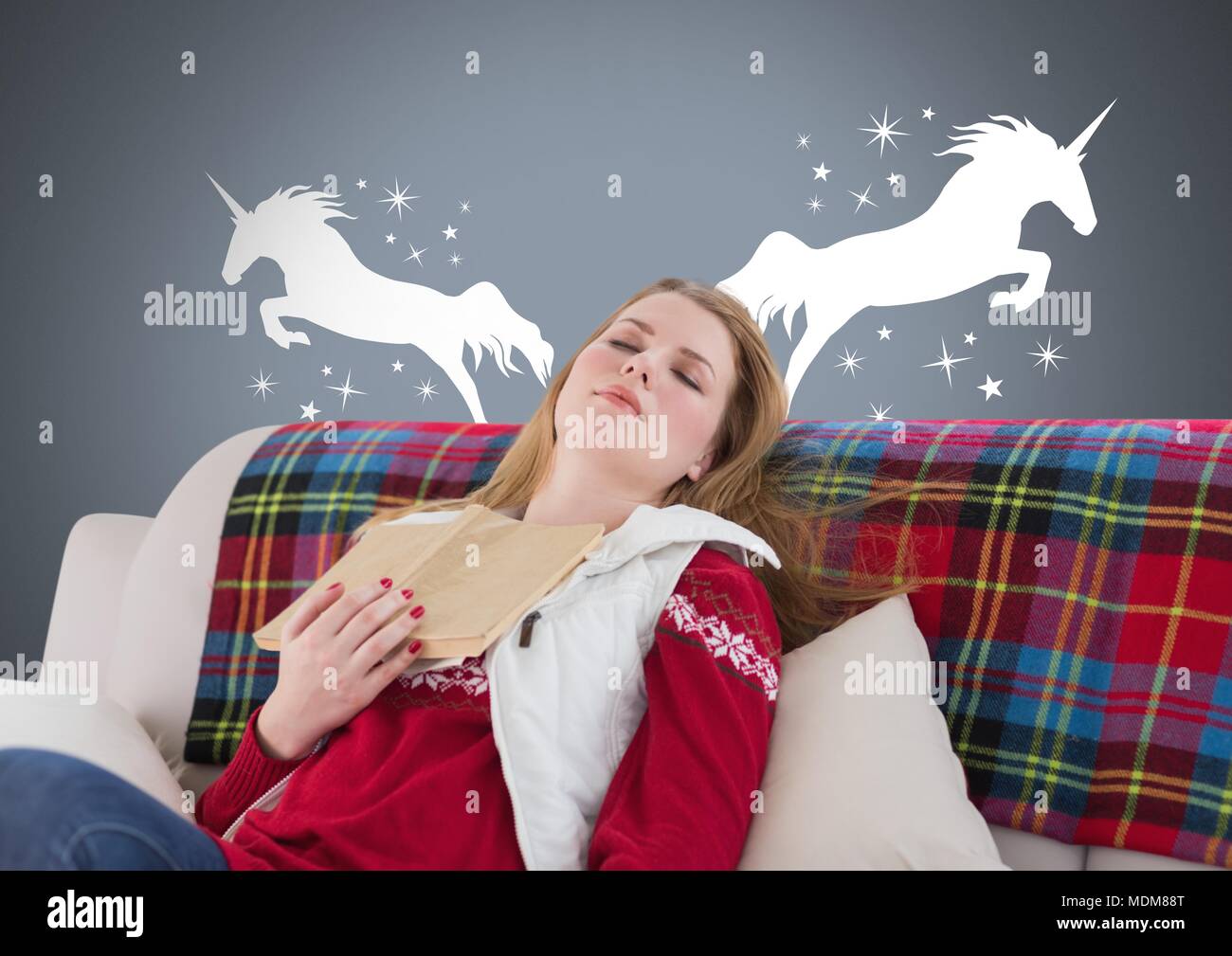 La donna addormentata sognando di unicorns con libro e stelle Foto Stock