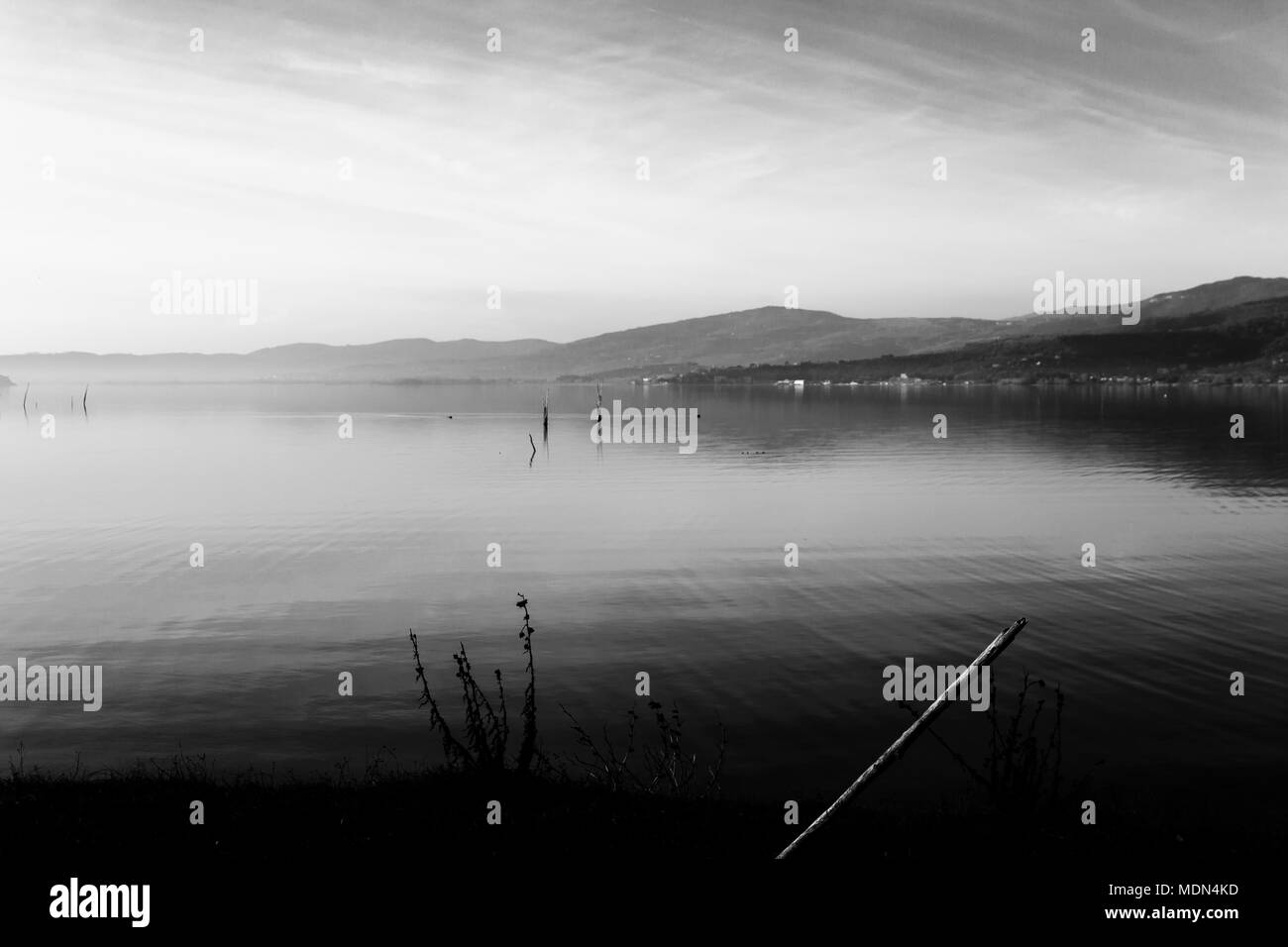 Bellissima vista del lago Trasimeno (Umbria, Italia), con colline e cielo riflettendo sull'acqua Foto Stock