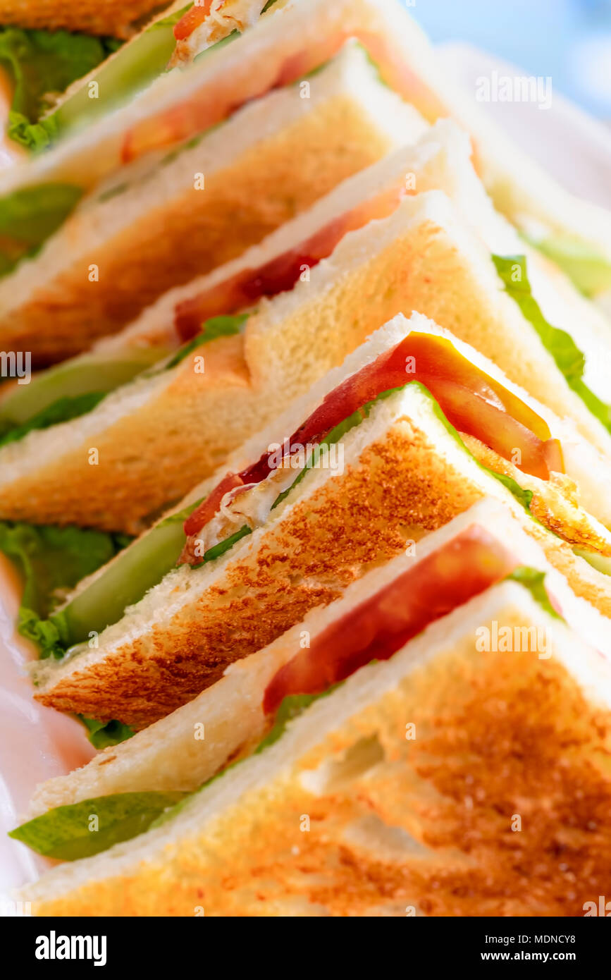 Riga di tostatura del club sandwich con pomodoro, lattuga e uovo mayonaise. Concetto di prima colazione con fast food. Foto Stock