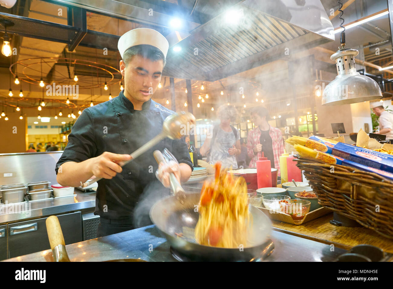 SAINT PETERSBURG, Russia - circa agosto, 2017: uomo sapientemente preparare il cibo in un wok Marketplace al ristorante. Foto Stock