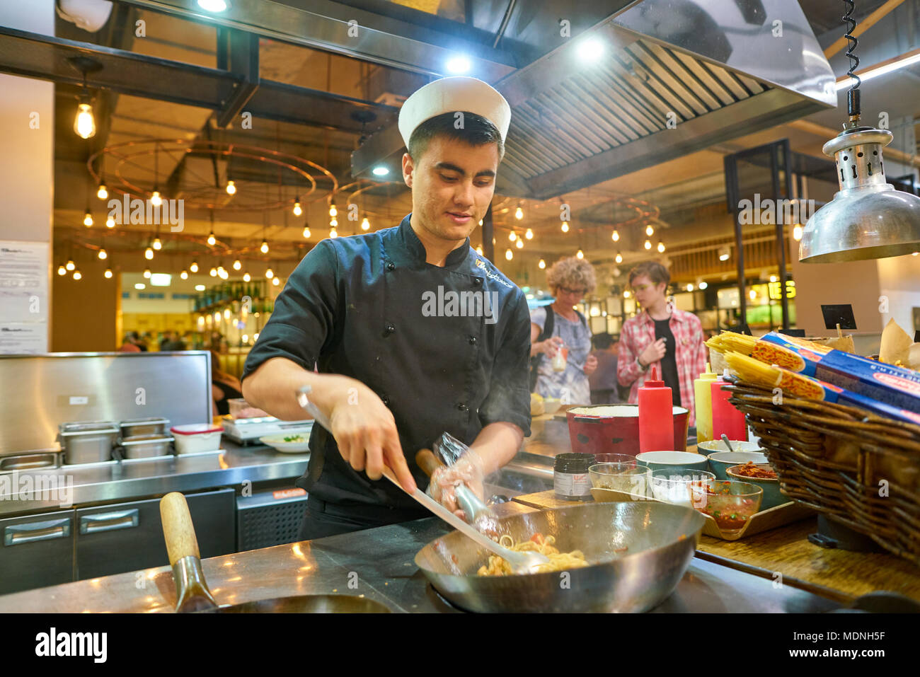 SAINT PETERSBURG, Russia - circa agosto, 2017: uomo sapientemente preparare il cibo in un wok Marketplace al ristorante. Foto Stock