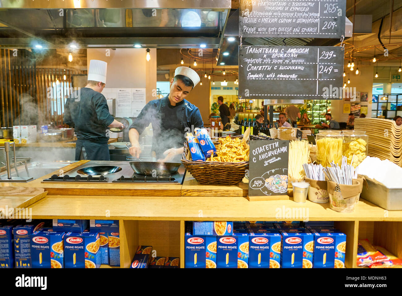 SAINT PETERSBURG, Russia - circa agosto, 2017: uomo sapientemente preparare il cibo in un wok Marketplace al ristorante. Foto Stock