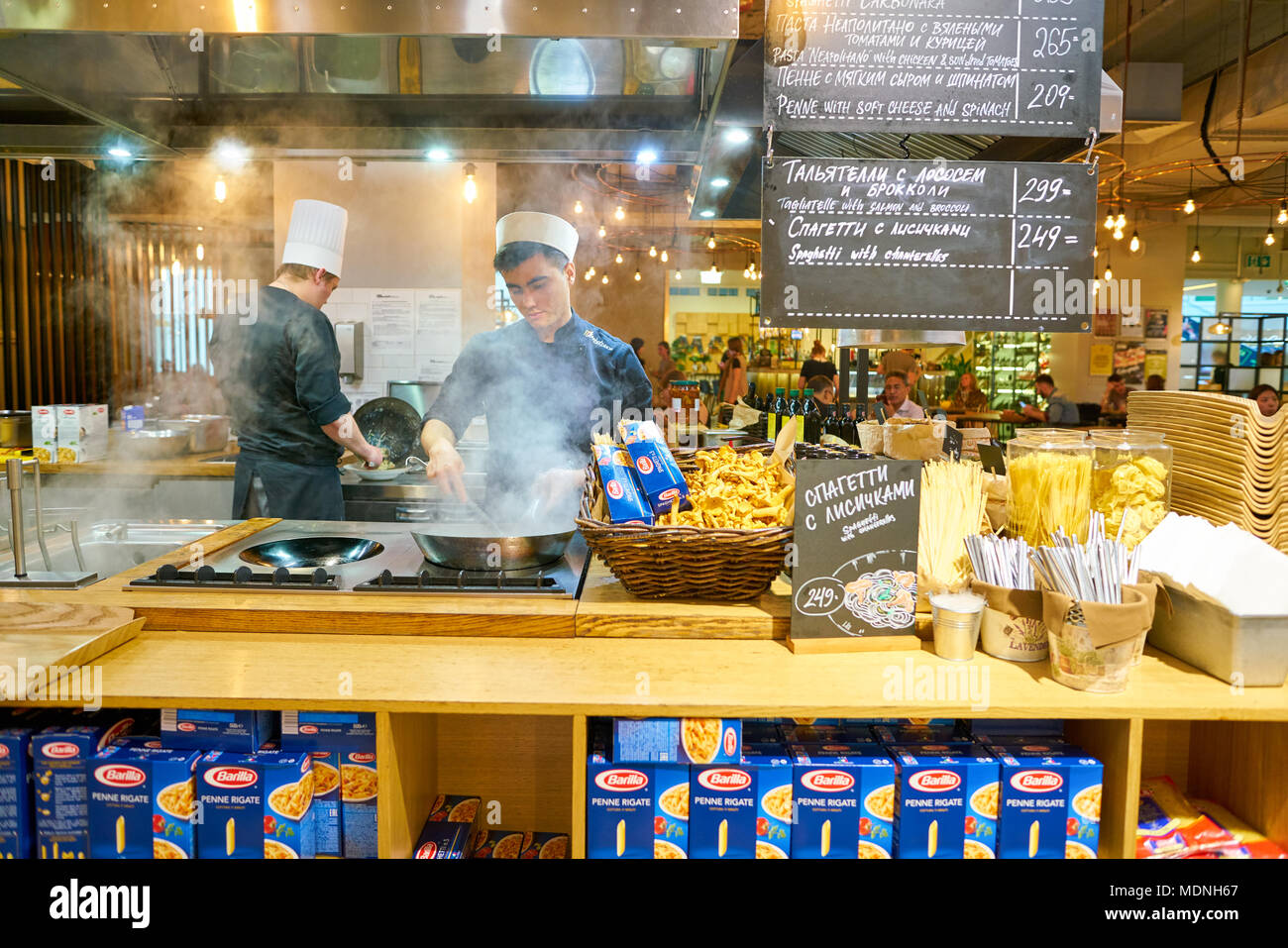 SAINT PETERSBURG, Russia - circa agosto, 2017: uomo sapientemente preparare il cibo in un wok Marketplace al ristorante. Foto Stock