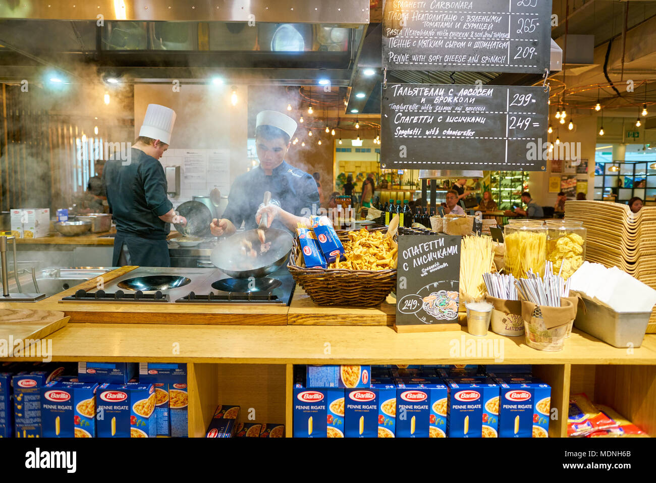 SAINT PETERSBURG, Russia - circa agosto, 2017: uomo sapientemente preparare il cibo in un wok Marketplace al ristorante. Foto Stock