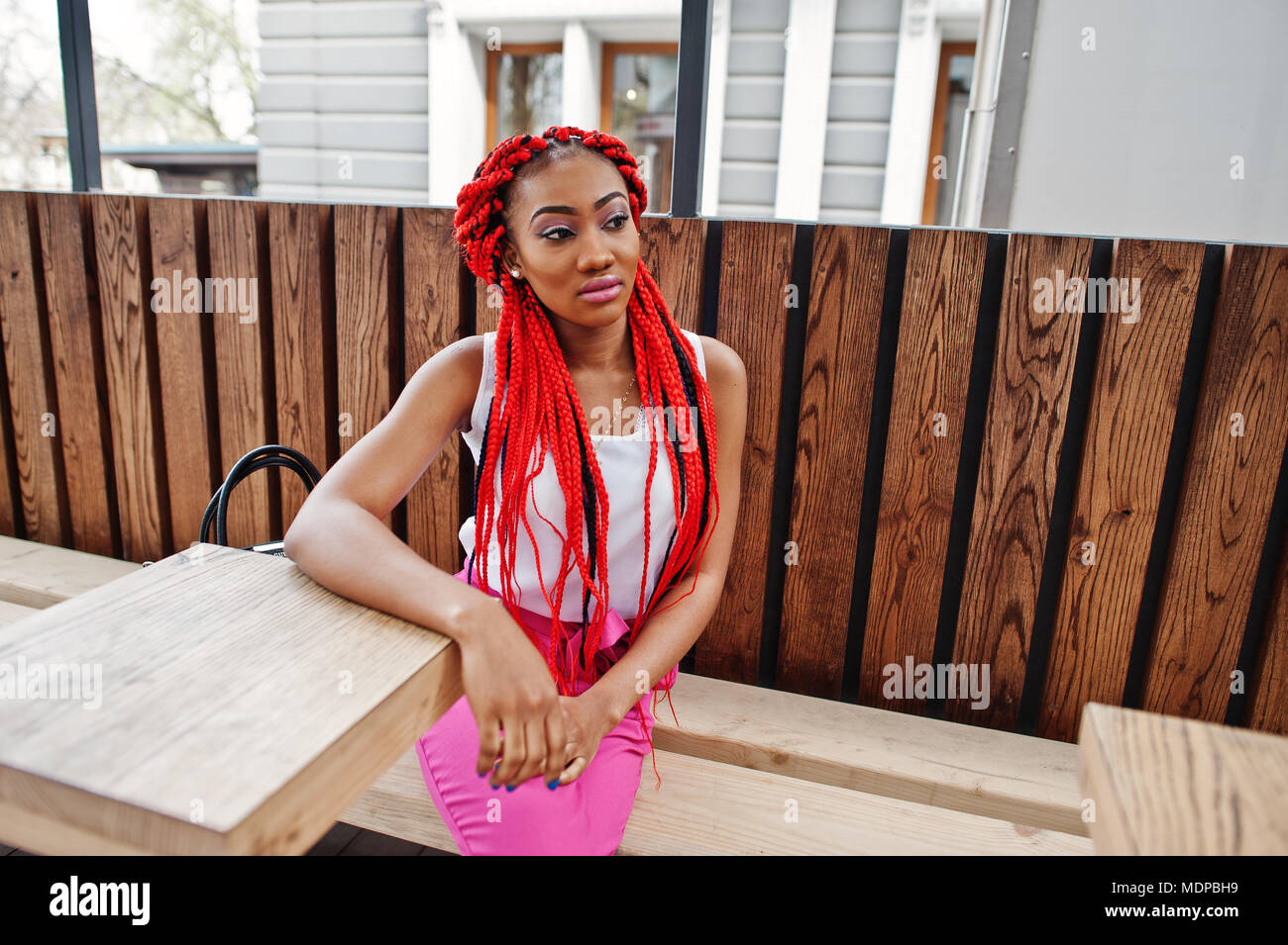 Moda African American Girl in pantaloni rosa e rosso timori poste all'esterno. Foto Stock