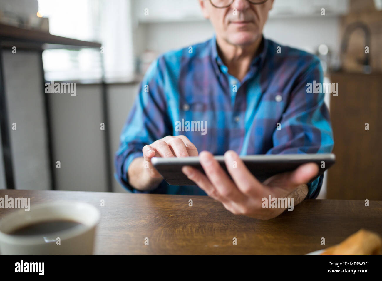 Tagliate il ritratto di uomo senior azienda tablet in cucina Foto Stock
