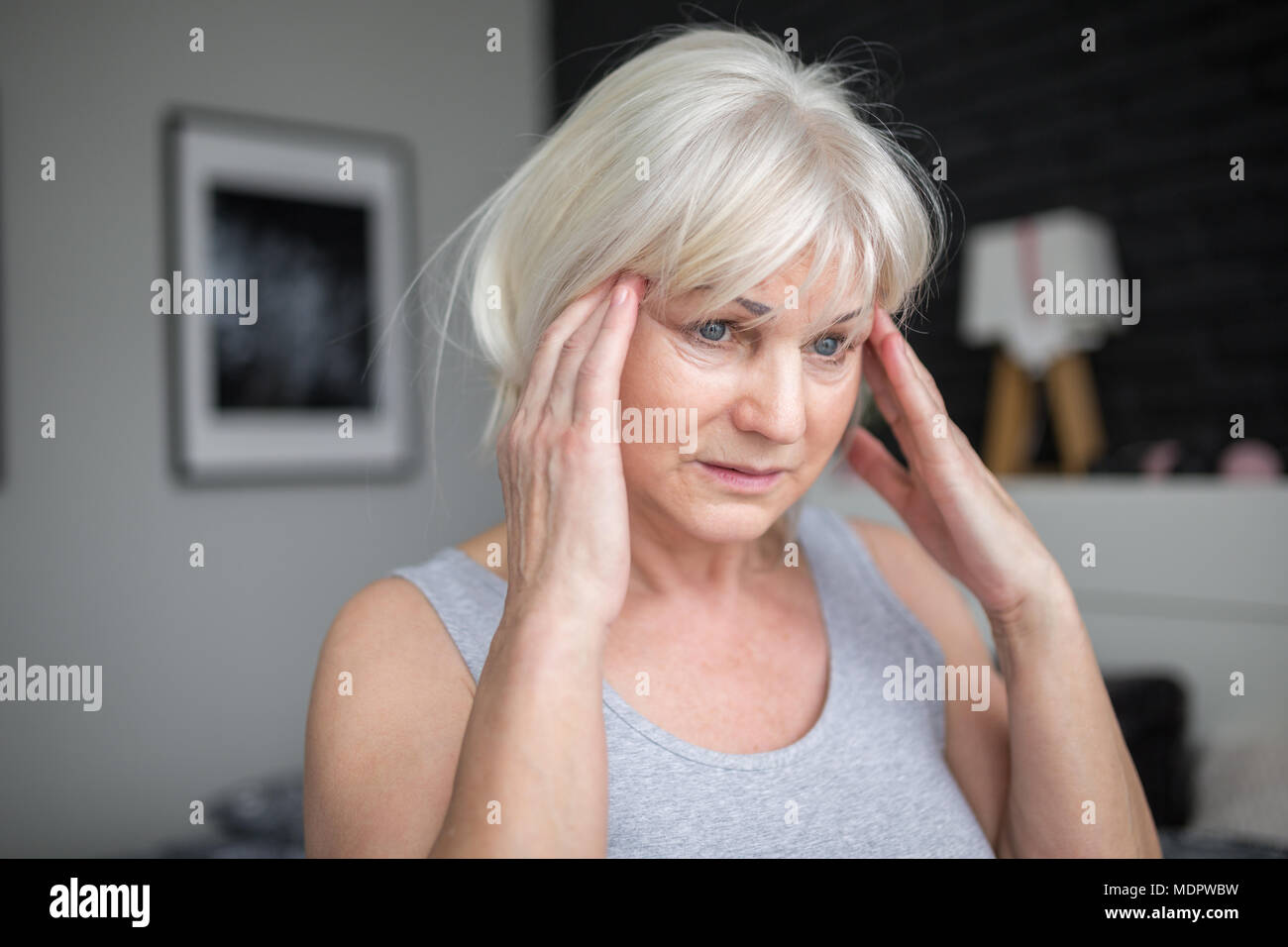 Ritratto di donna senior con mal di testa tenendo le mani sulle tempie Foto Stock