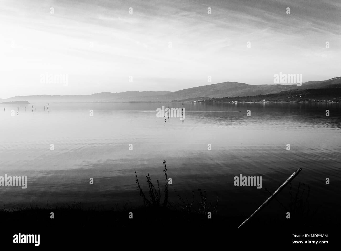 Bellissima vista del lago Trasimeno (Umbria, Italia), con colline e cielo riflettendo sull'acqua Foto Stock