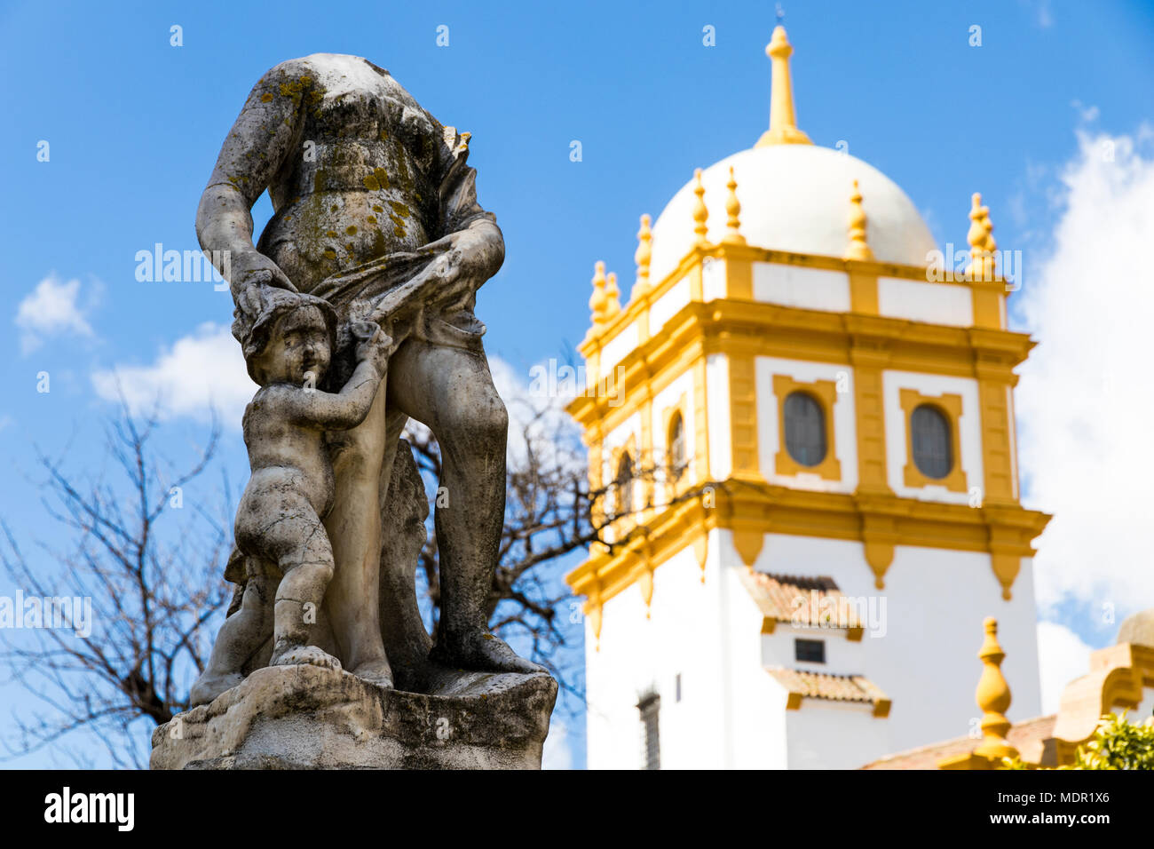 Siviglia, Spagna. Viste di una testa di statua in Jardines de las Delicias giardini pubblici, con la torre del padiglione argentino Foto Stock
