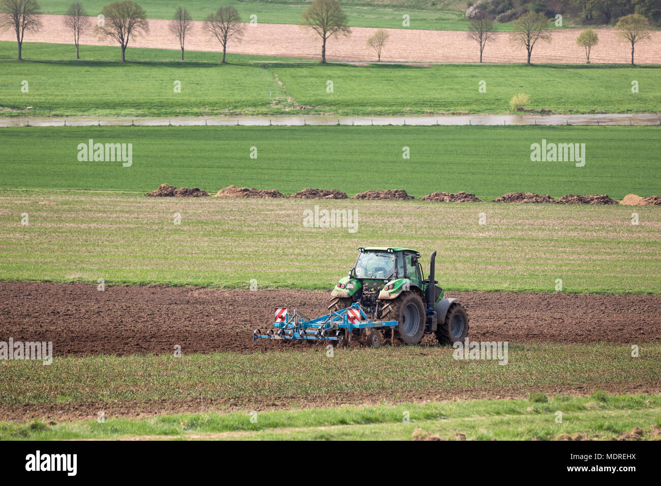 Traktor zieht Egge zur Bodenauflockerung Foto Stock