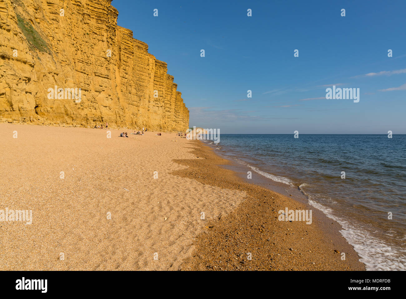 West Bay, Dorset, England, Regno Unito - 23 Aprile 2017: le scogliere di West Bay (visto nella serie TV Broadchurch) con persone sulla spiaggia Foto Stock