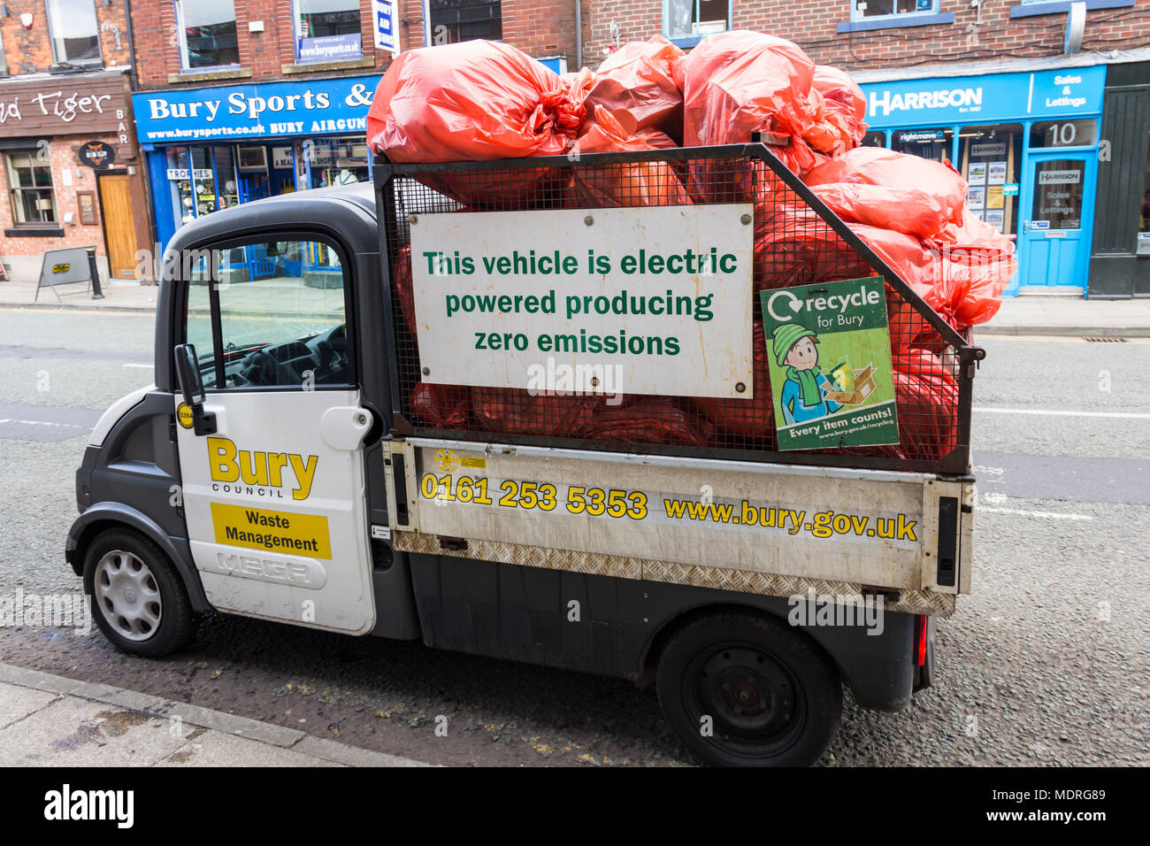 Aixam Mega ribaltabile carrello elettrico, pubblicità la sua Zero Emissioni credenziali. Utilizzato da Bury consiglio, per raccogliere il contenuto della città cestini. Foto Stock
