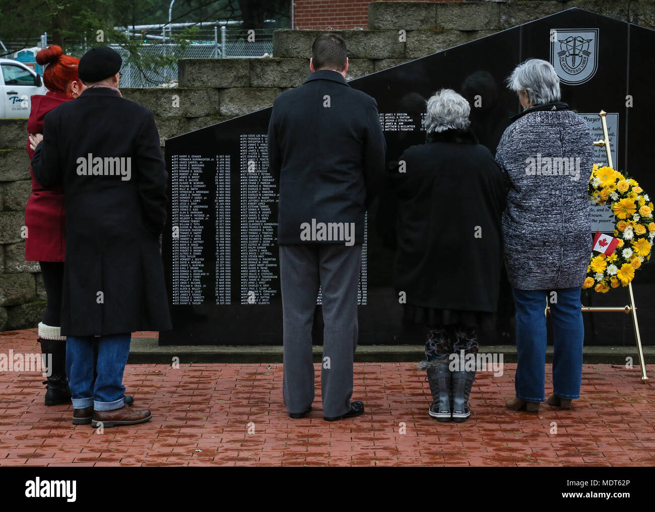 Stella d'oro famiglie ricordare i loro cari al memorial wall durante la settimana di Mentone cerimonie di apertura nella parte anteriore del primo Special Forces Group (Airborne) Sede a base comune Lewis McChord, Wa., 4 dicembre 2017. Menton settimana celebra le forze speciali patrimonio, come il suo predecessore è stato il primo servizio speciale forza, che ha sciolto in Menton, Francia alla fine della II Guerra Mondiale su dicembre 5, 1944. L'unità, comunemente denominato "Devils Brigade," è accreditato con un record distinto delle operazioni non convenzionali dietro le linee nemiche. Stati Uniti Esercito foto di Sgt. Brandon Welsh Foto Stock