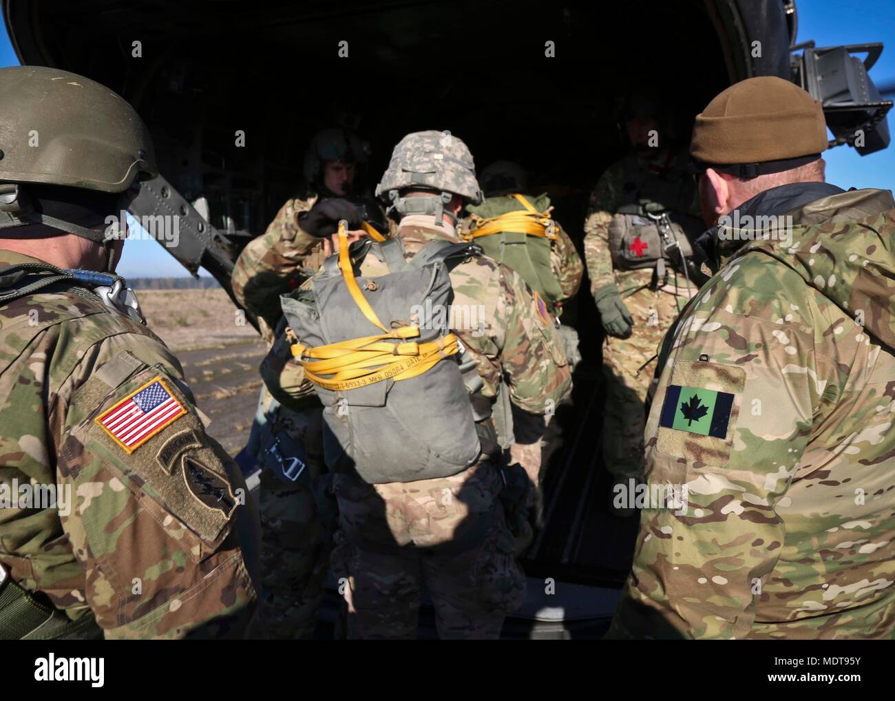 I membri del primo Special Forces Group (Airborne) condurre un'operazione aerea con il Canadese per le operazioni speciali (Reggimento CSOR) durante la settimana di Mentone a base comune Lewis-Mccorda, Wa., Dicembre 6, 2017. Dopo il salto, soldati da 1SFG (A), Filippino e paracadutisti canadese ha condotto una cerimonia in cui hanno scambiato i loro paesi' ali di salto con uno un altro. Foto Stock