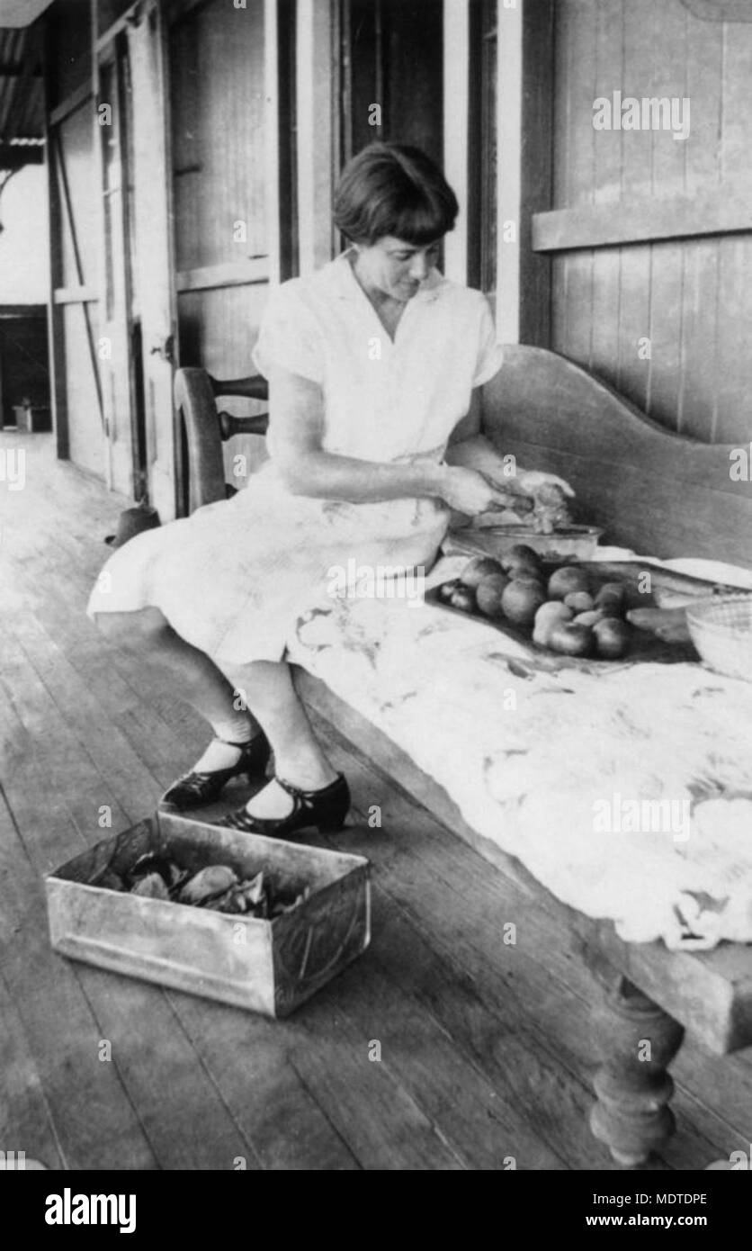 Giovane donna sulla veranda preparare frutta per conserve, ca. Foto Stock