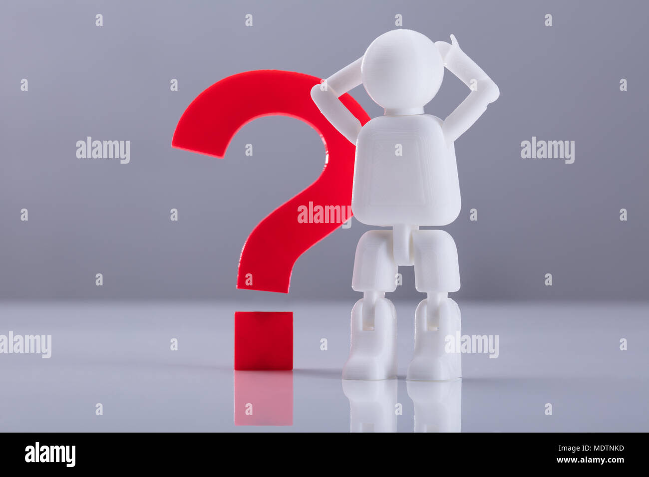 Una figura umana in piedi accanto al punto interrogativo rosso segno su sfondo grigio Foto Stock