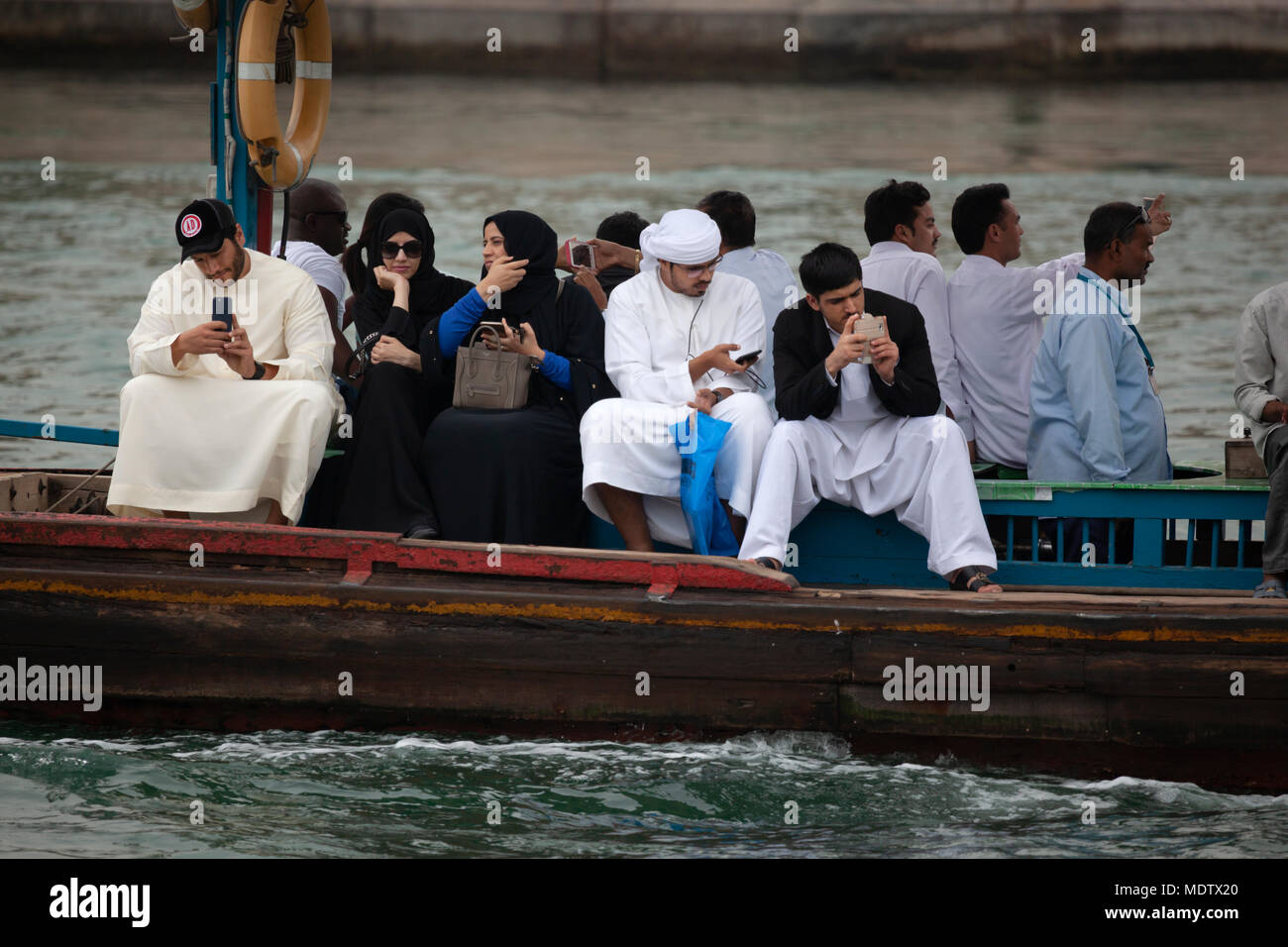 La popolazione locale che attraversa il Torrente di Dubai su un abra, Dubai, Emirati Arabi Uniti, Medio Oriente Foto Stock