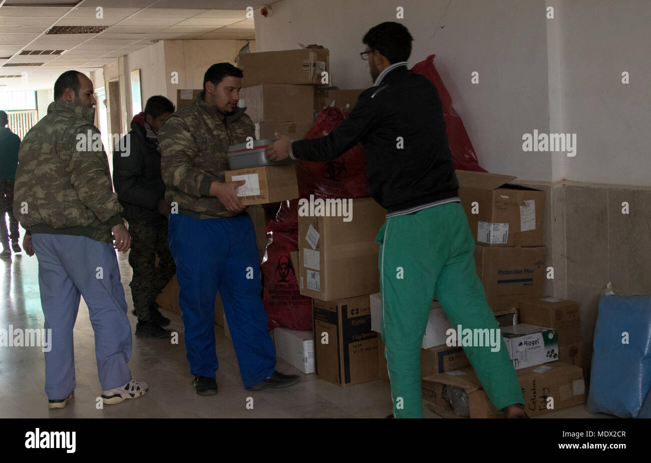 Un camion che trasportava forniture mediche dall'ospedale civile di Al Hasakah city è scaricato da diversi siriano Forze Democratiche soldati che vivono e lavorano presso la clinica medica in Shaddadi, Siria, Dic 10, 2017. Queste forniture mediche hanno dato alla SDF per assistere il medico locale e frontline ambulanze in Shaddadi. L'ospedale Shaddadi, attualmente gestito da SDF come una clinica medica in una porzione dell'edificio, era il più grande ospedale nazionale in Hasakah Governate prima Daesh terroristi hanno preso il controllo dell'edificio. L'obiettivo per la SDF è di completare la transizione di costruzione indietro ad un c Foto Stock