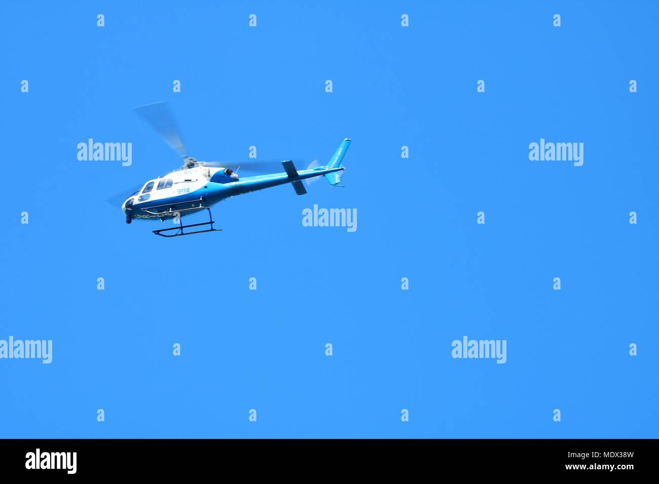 National Grid blu e bianco elicottero in volo contro un cielo blu Foto Stock