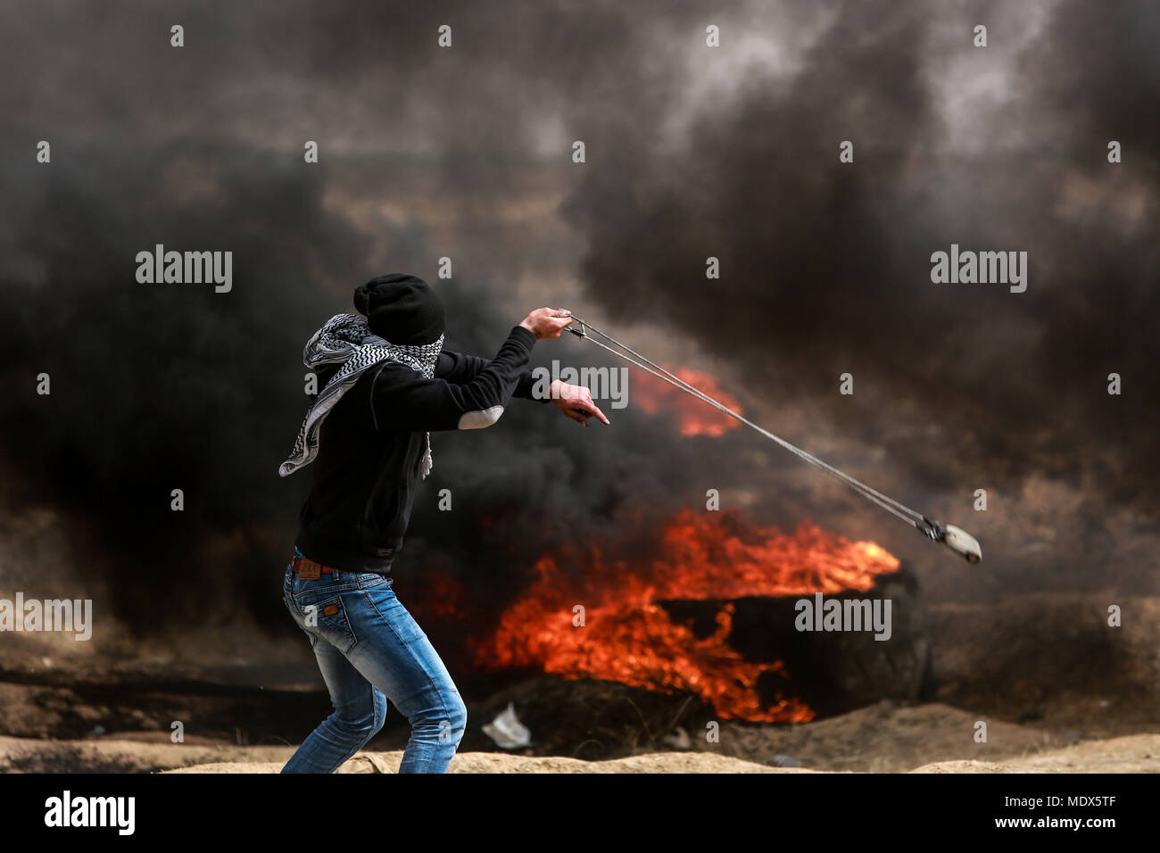 La striscia di Gaza. Xx Apr, 2018. Un manifestante palestinese scaglia pietra durante gli scontri con le forze israeliane, a est di Gaza City, il 20 aprile 2018. Credito: Stringer/Xinhua/Alamy Live News Foto Stock