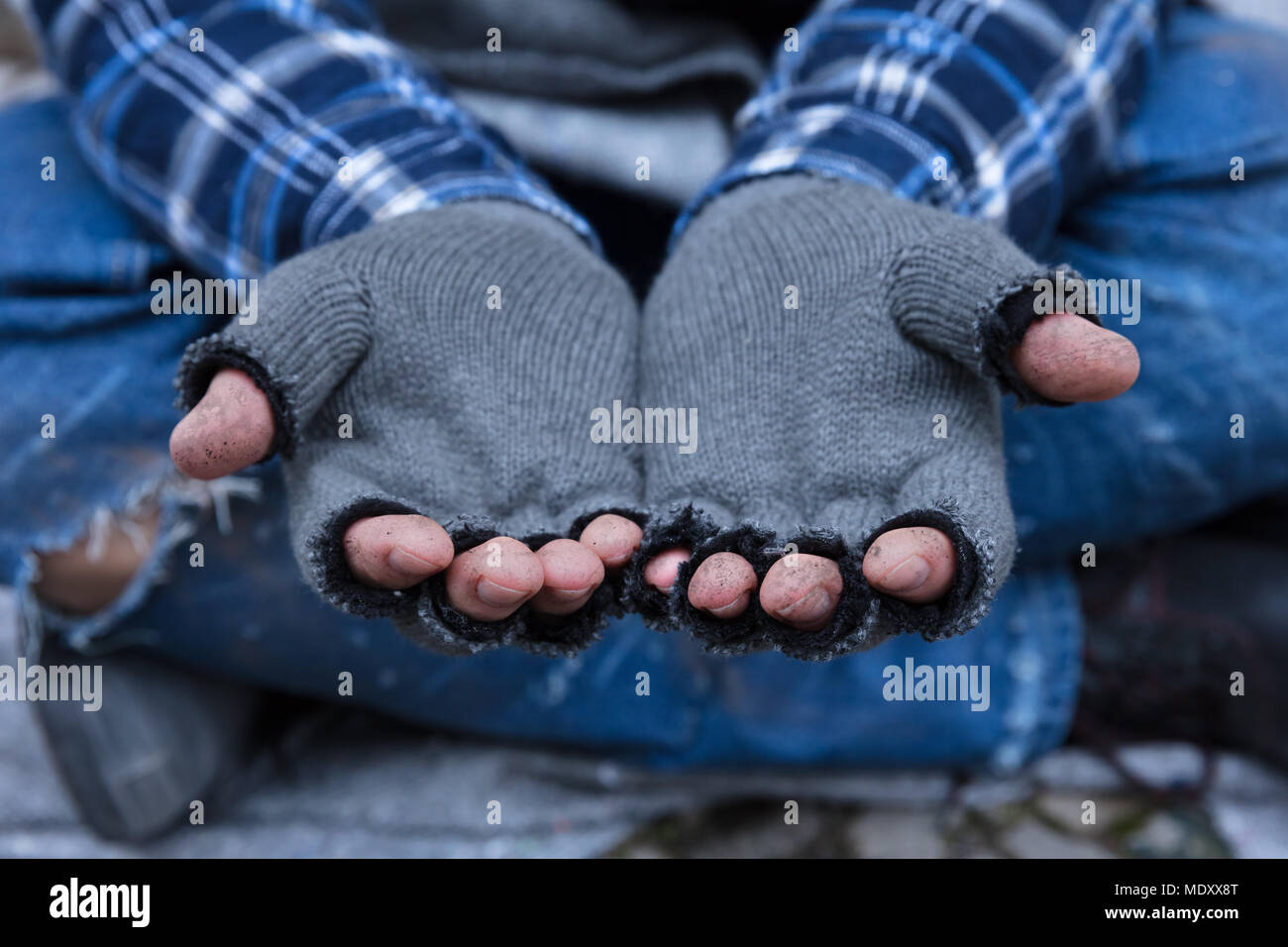 Close-up di un Beggar's le dita sporche indossando i guanti Foto Stock
