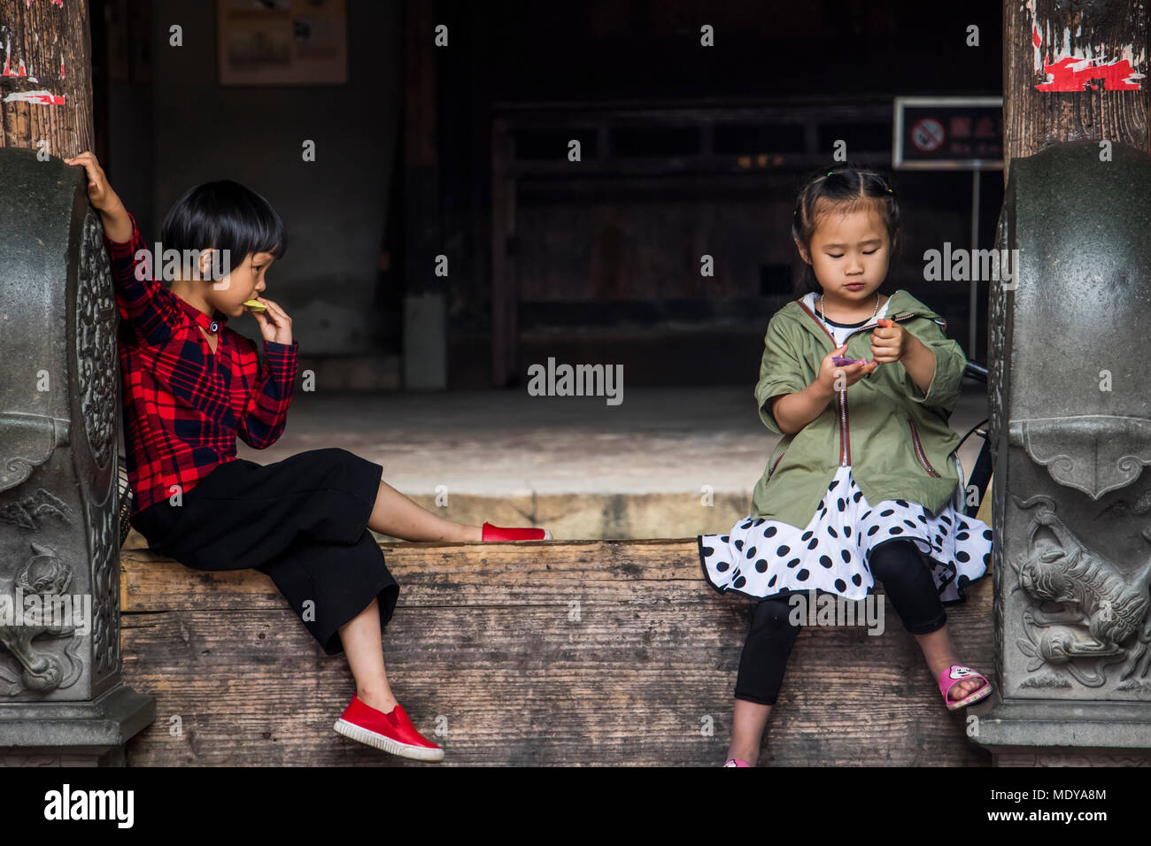 Due giovani ragazze nell'Edificio Eryi, affermano la DADI Tulou; Fujian, Cina Foto Stock