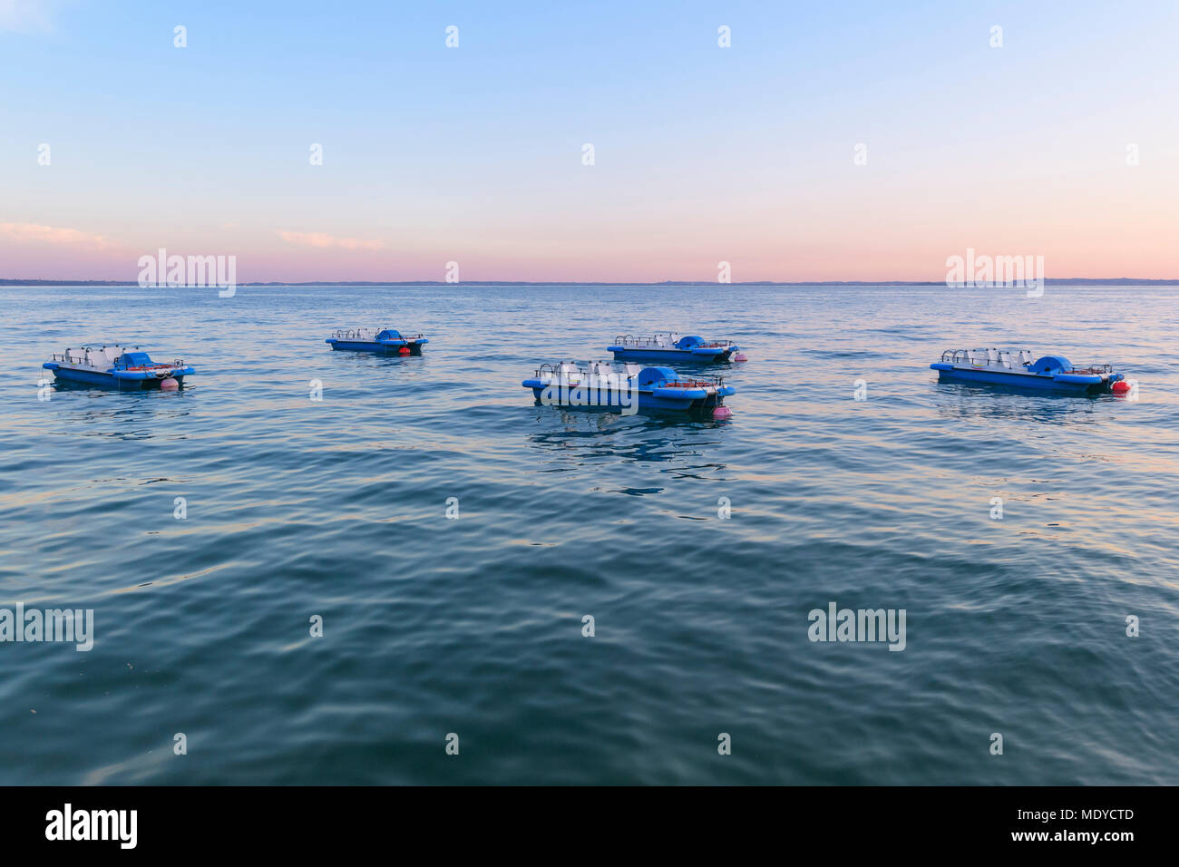 Lago di Garda Lago di Garda) ancorata con barche a pedali al crepuscolo in Garda in Veneto, Italia Foto Stock