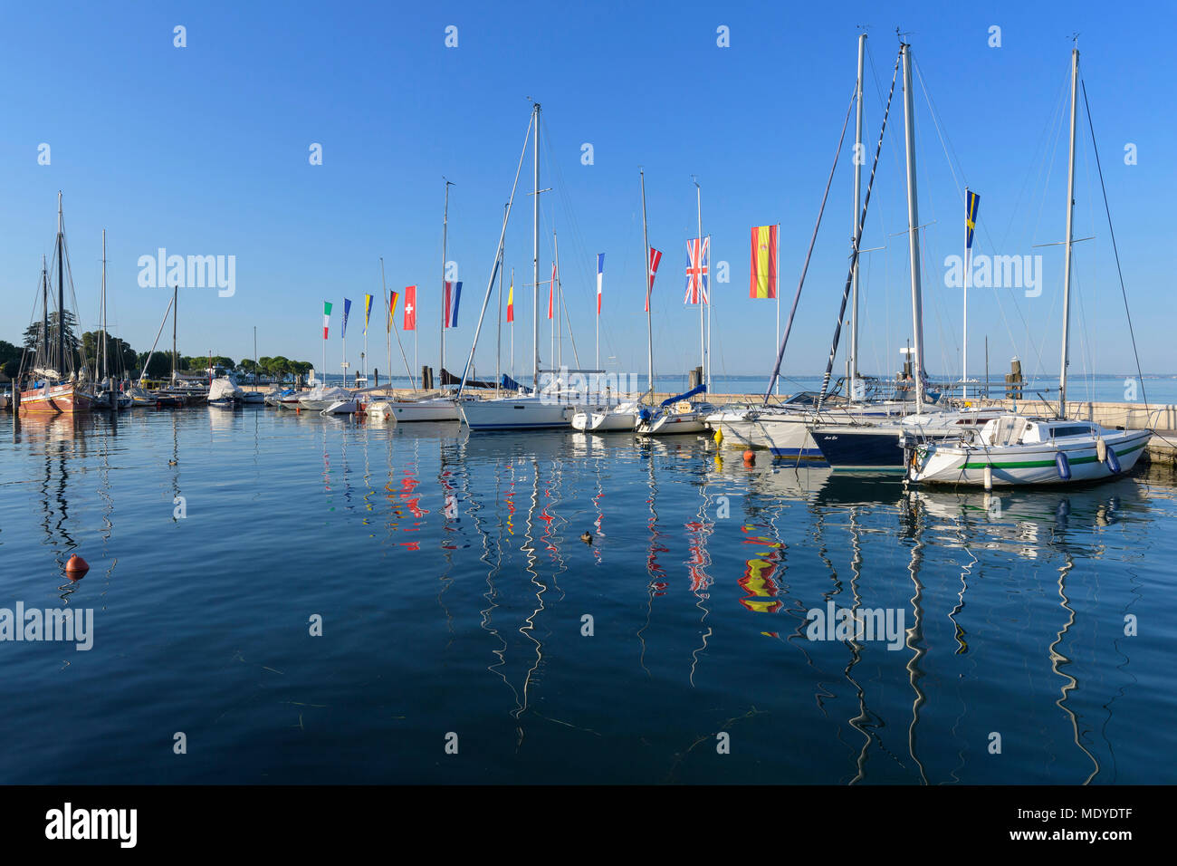 Fila di barche colorate e bandiere europee nel porto Marina sul Lago di Garda Lago di Garda) a Bardolino in Veneto, Italia Foto Stock