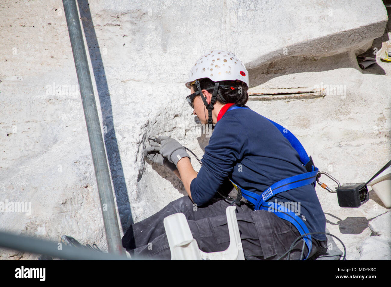 In febbraio, 2015 Rinnovo dettagliate sono proseguiti i lavori sulla Fontana di Trevi a Roma. Una donna che indossa copricapo di protezione sul lato della fontana. Foto Stock