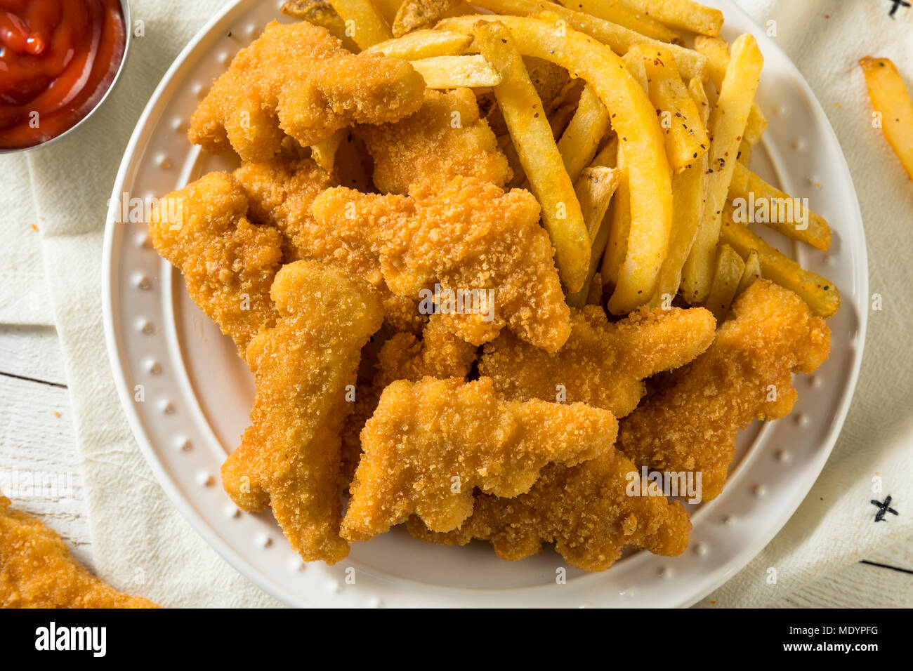 Per bambini a forma di dinosauro pepite di pollo pronto a mangiare Foto Stock