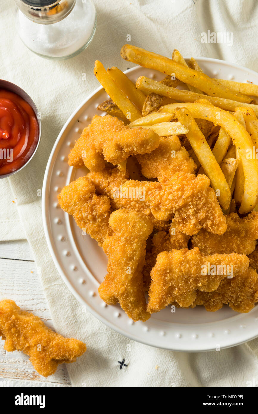 Per bambini a forma di dinosauro pepite di pollo pronto a mangiare Foto Stock