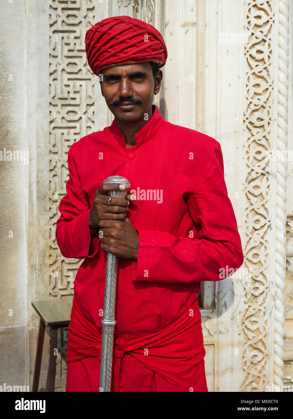 Un uomo indiano in rosso tradizionale abbigliamento indiano al City Palace; Jaipur, Rajasthan, India Foto Stock