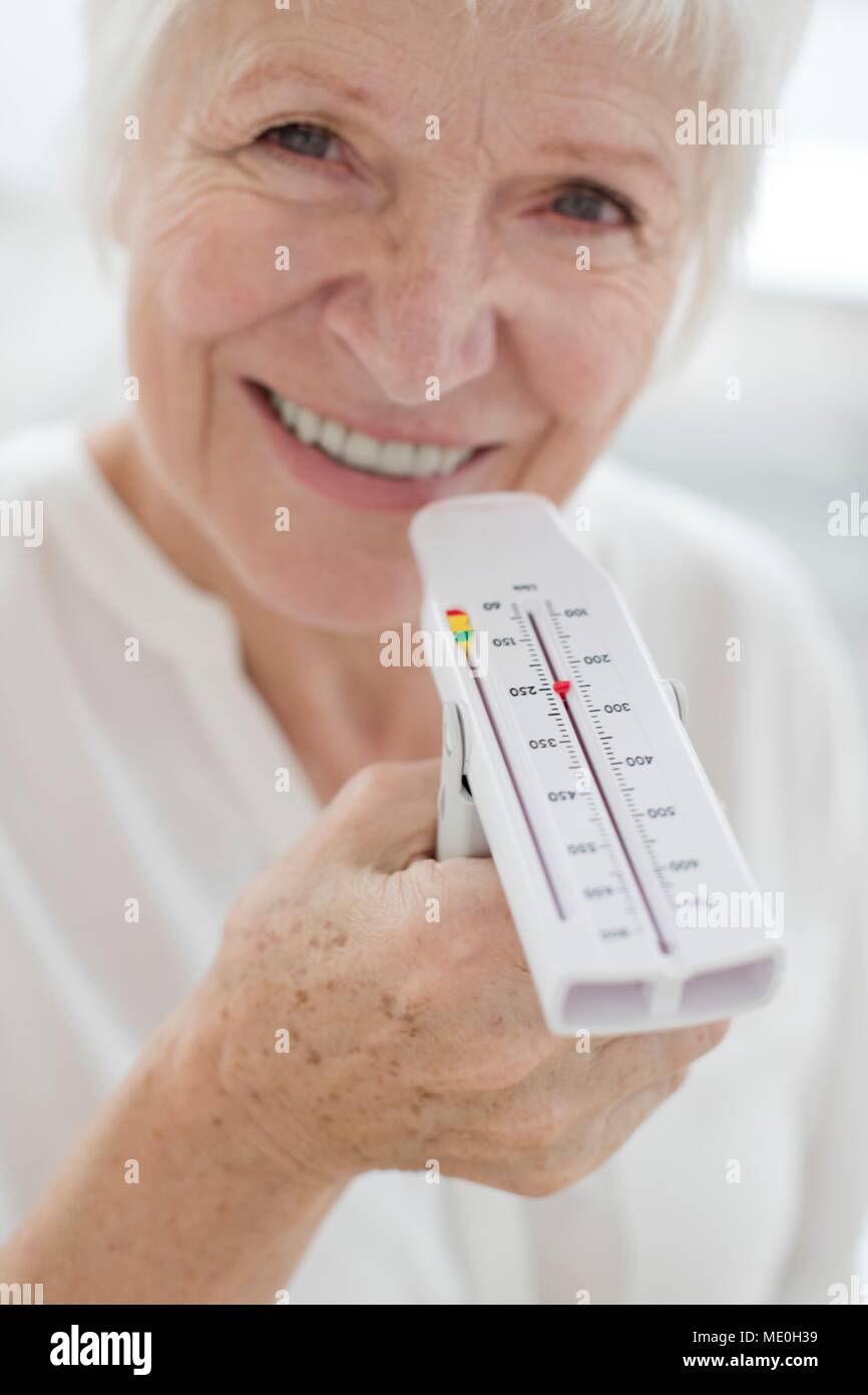 Senior donna holding misuratore del picco di flusso espiratorio. Foto Stock