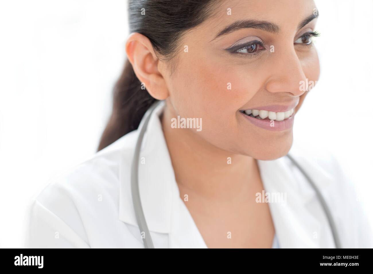 Medico donna sorridente e lo sguardo lontano, ritratto. Foto Stock