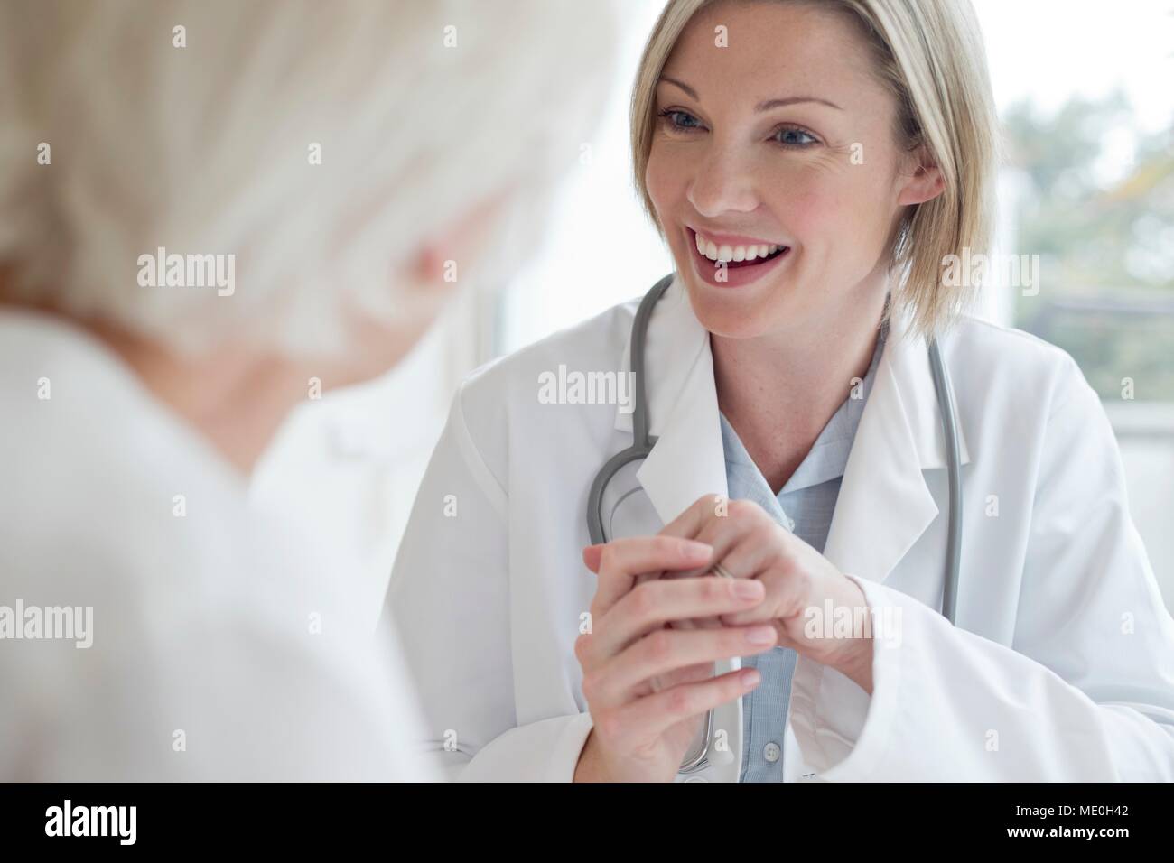 Medico donna sorridente verso il paziente. Foto Stock