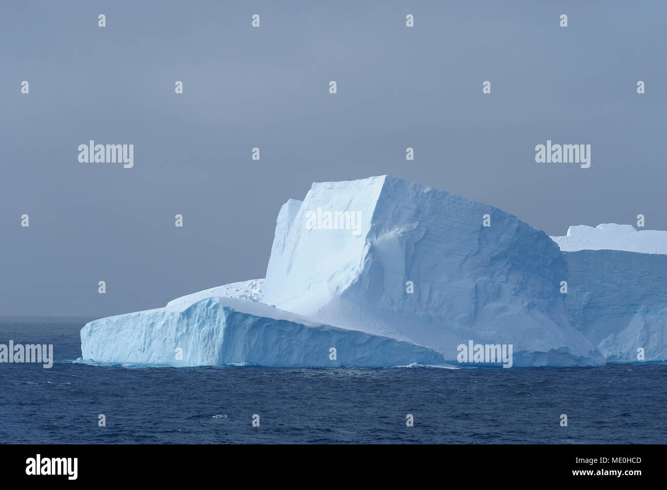 Parte di un iceberg che riflette la luce su un nuvoloso giorno nell'Antartico sana alla penisola antartica, Antartide Foto Stock
