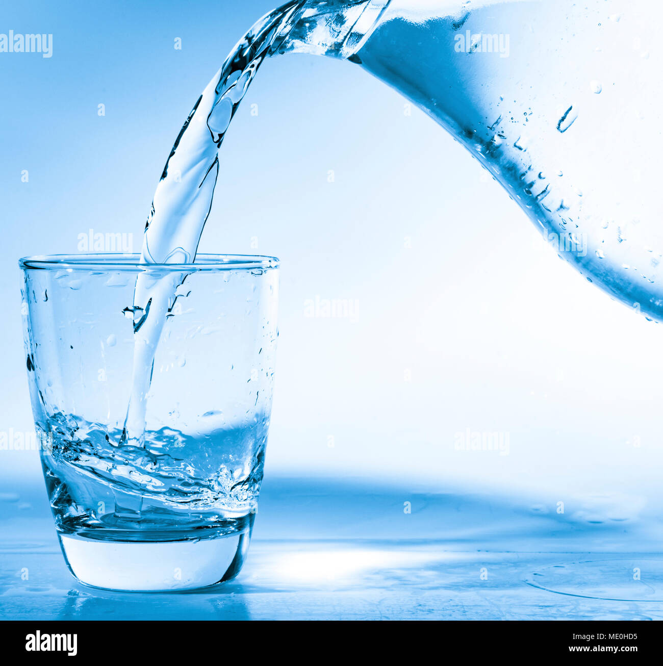 Versare acqua in vetro a partire da una caraffa. Foto Stock