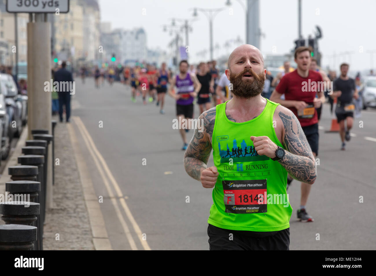 Brighton, Sussex, Regno Unito; 15 aprile 2018; l'uomo con il tatuaggio e la barba in esecuzione nella maratona di Brighton Foto Stock