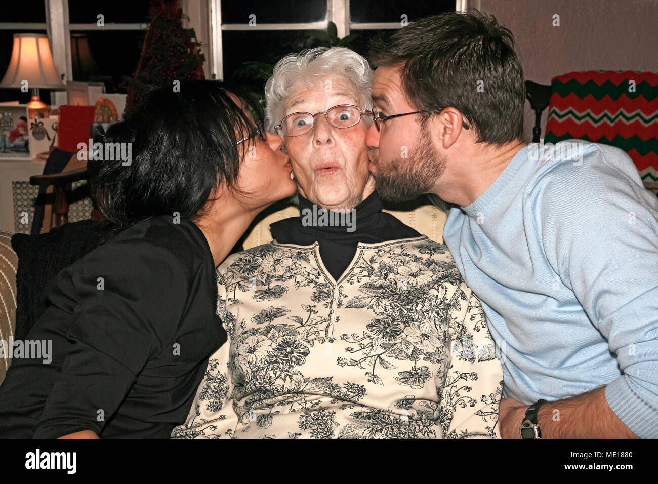 Nonna baciato dal nipote e nipote. Foto Stock