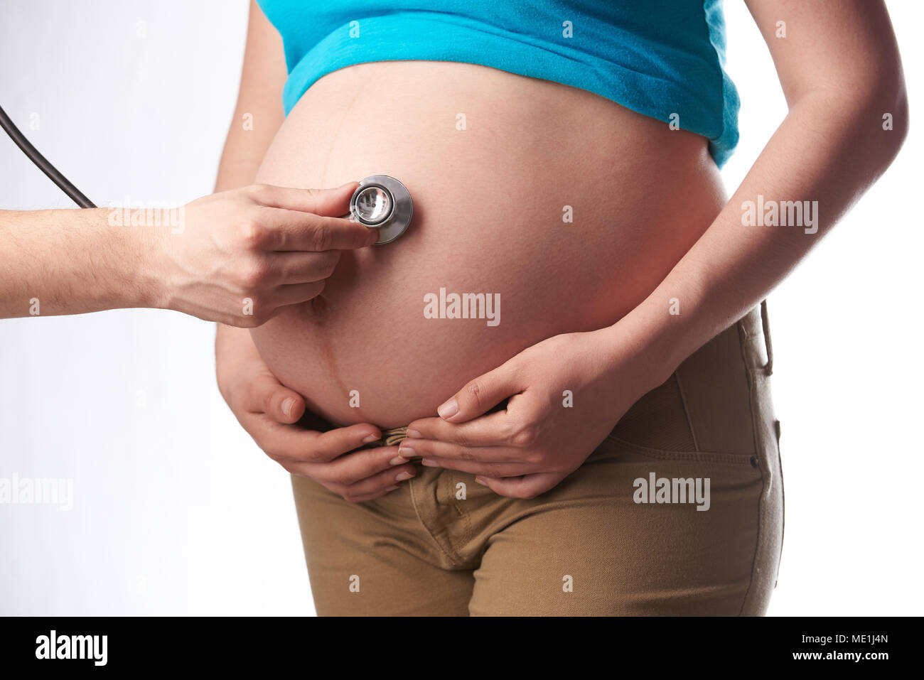 Donna incinta tema esame. Pancia in gravidanza il controllo con uno stetoscopio Foto Stock