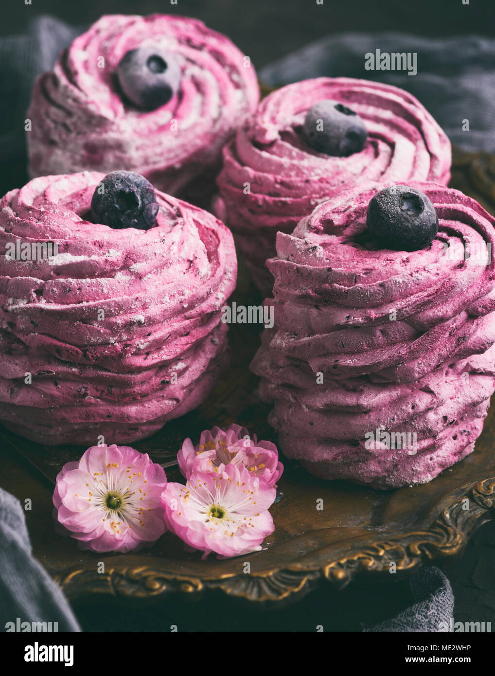 Aria rotondo marshmallows con mirtilli su una piastra di rame, vintage tonificante, close up Foto Stock