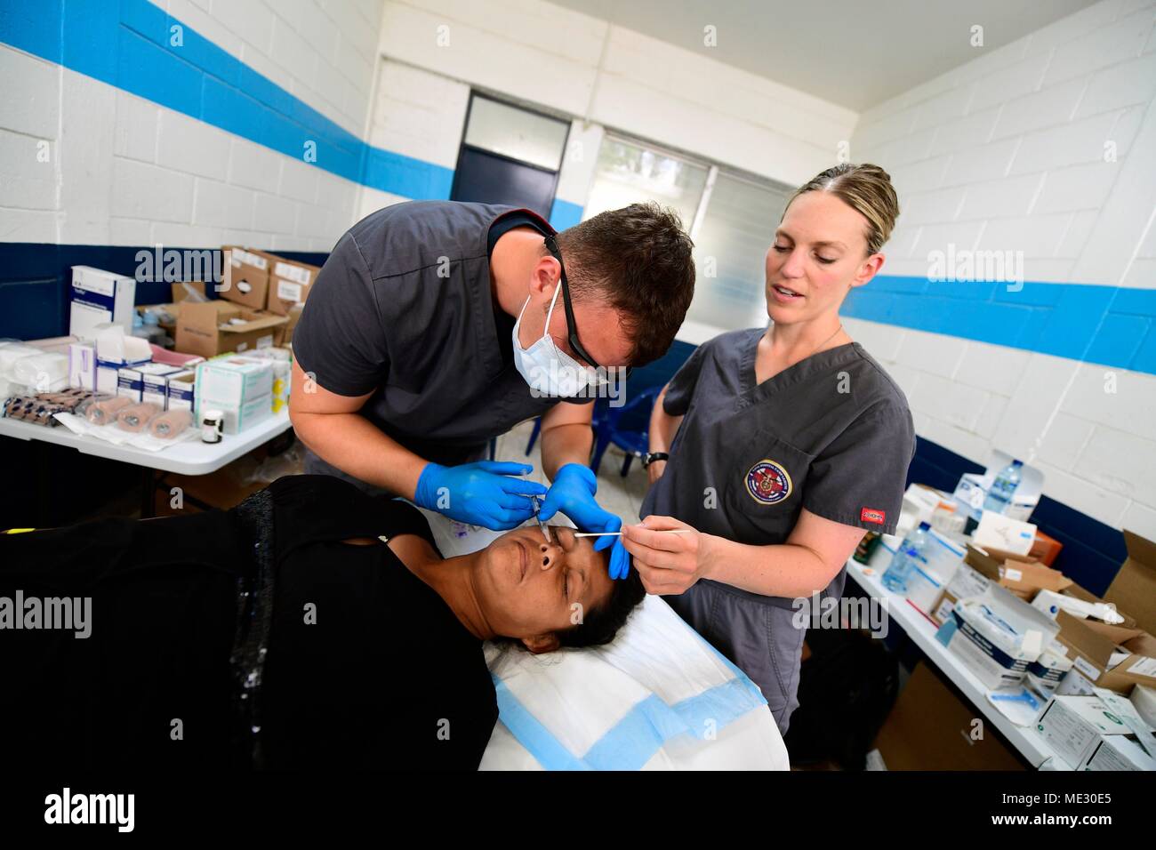 180417-N-VK873-0068 PUERTO BARRIOS, Guatemala (17 aprile 2018) Hospitalman Garrett Porter, di Farmington, Utah, e il tenente La Cmdr. Molla di Lia, di Rochester Hills, Michigan, iniettare un guatemalteco il naso con un anestetico locale a Puerto Barrios, Guatemala durante continuando promessa 2018. Stati Uniti Forze Navali Comando meridionale/STATI UNITI 4a flotta ha dispiegato una forza di eseguire continuando la promessa di comportamento civile-militare comprendente le operazioni di assistenza umanitaria, impegni di formazione e medico, dentista e supporto di veterinari in uno sforzo per mostrare il supporto degli Stati Uniti e di impegno per l'America centrale e del Sud. ( Foto Stock