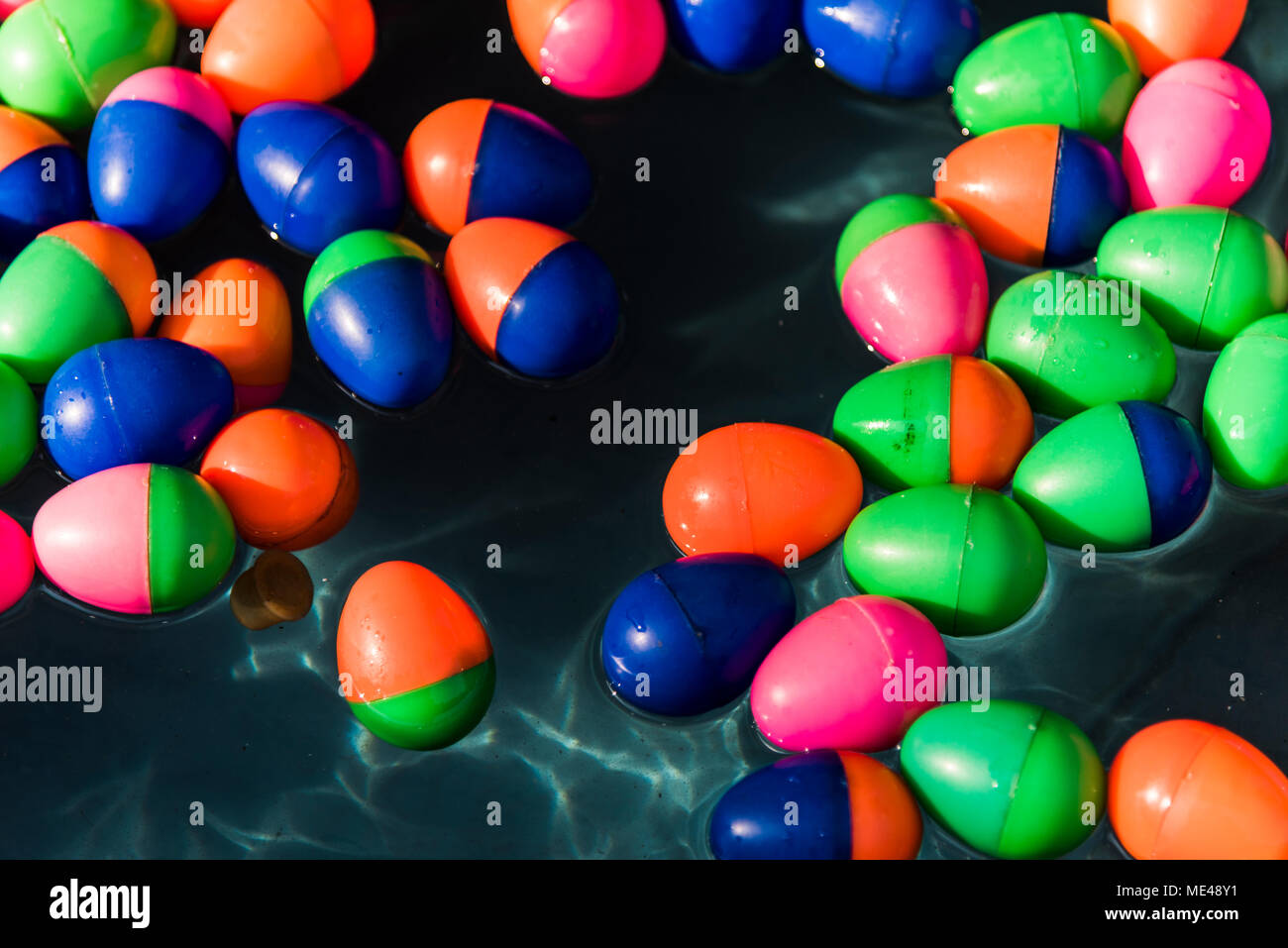Uova di plastica galleggianti in acqua Foto Stock