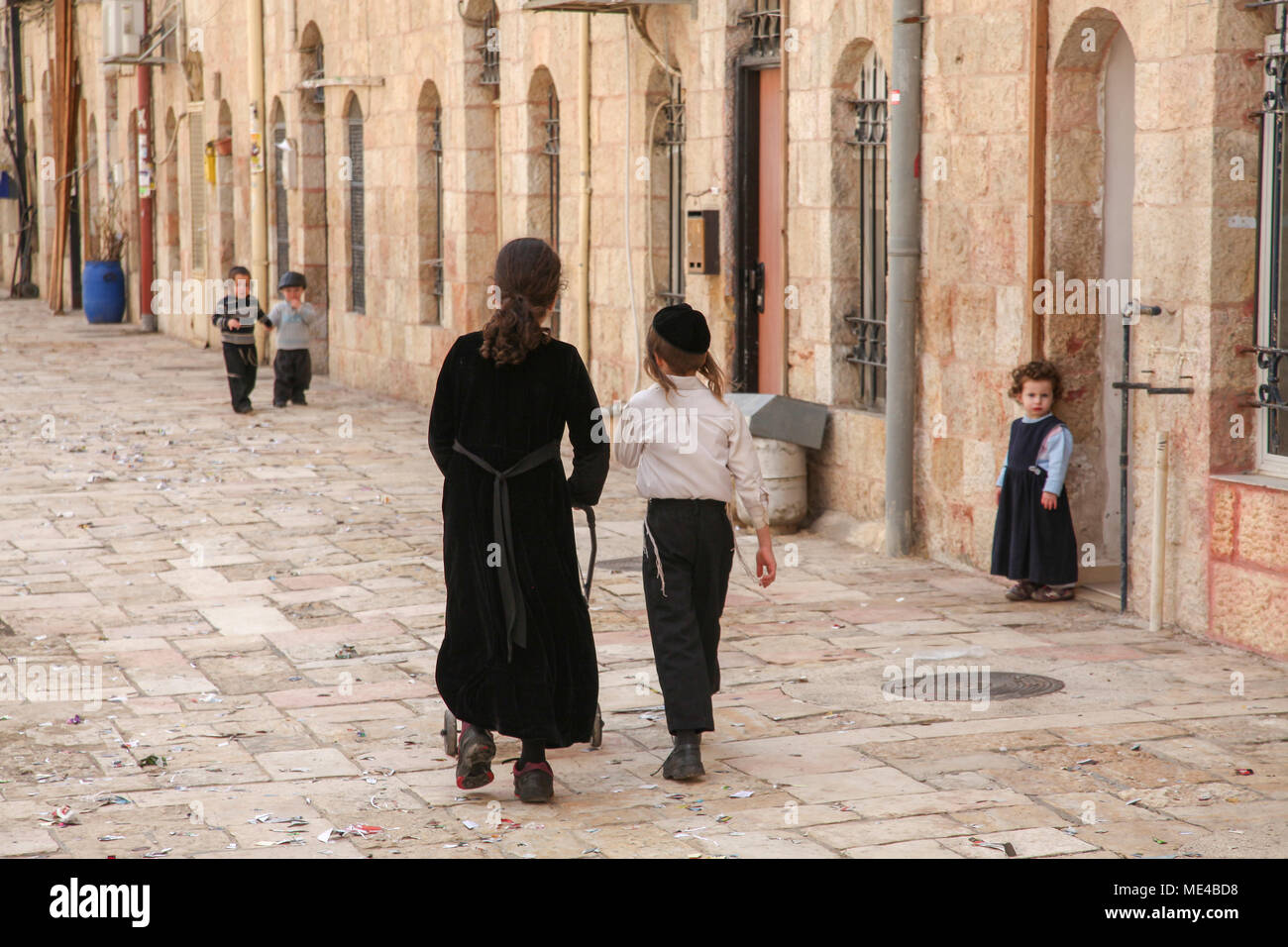 Israele a Gerusalemme il stretto vicolo del popolo ebraico Mea Shearim quartiere, giovani bambini che giocano in strada Foto Stock