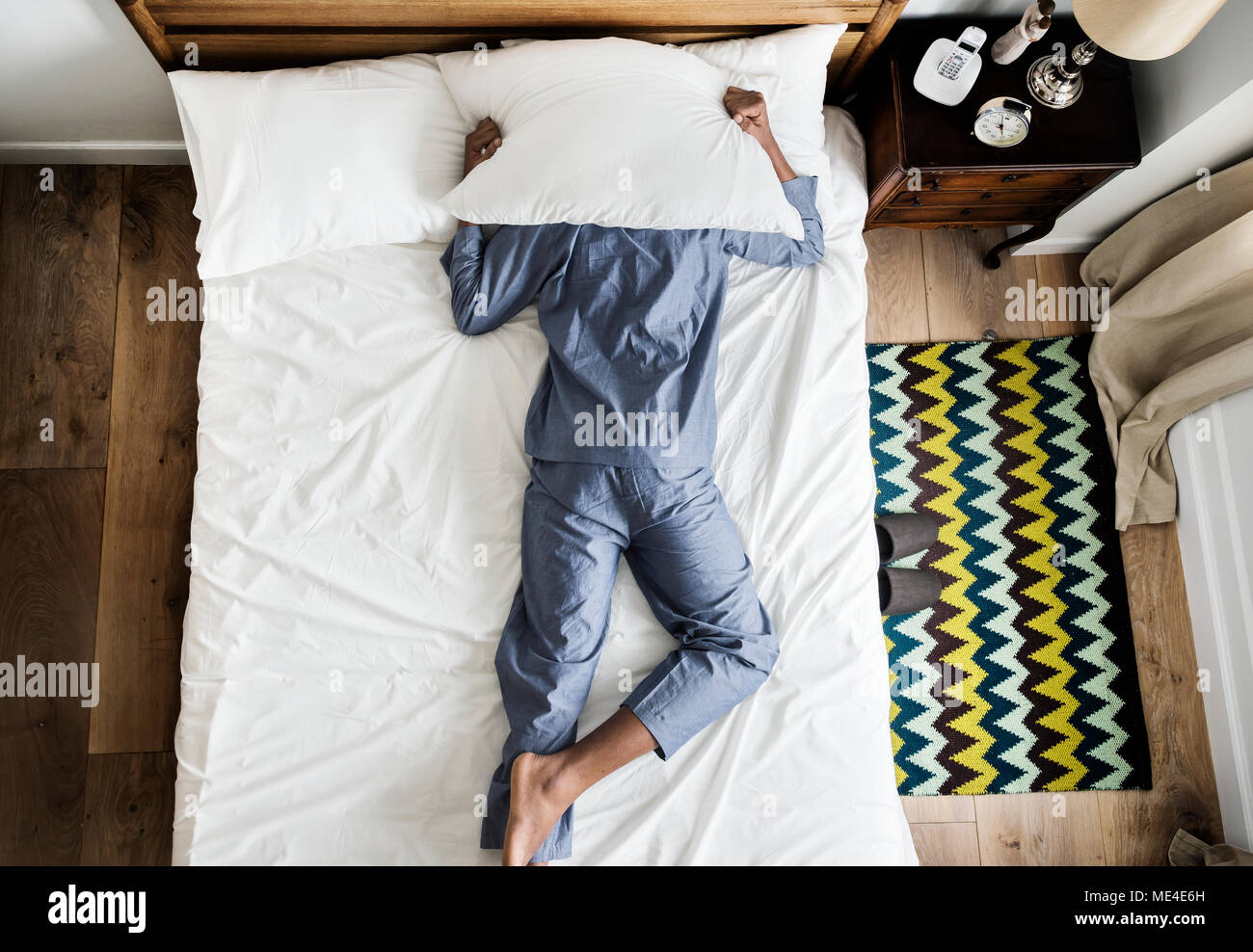 L'uomo sul letto insonnia e inquinamento acustico concept Foto Stock