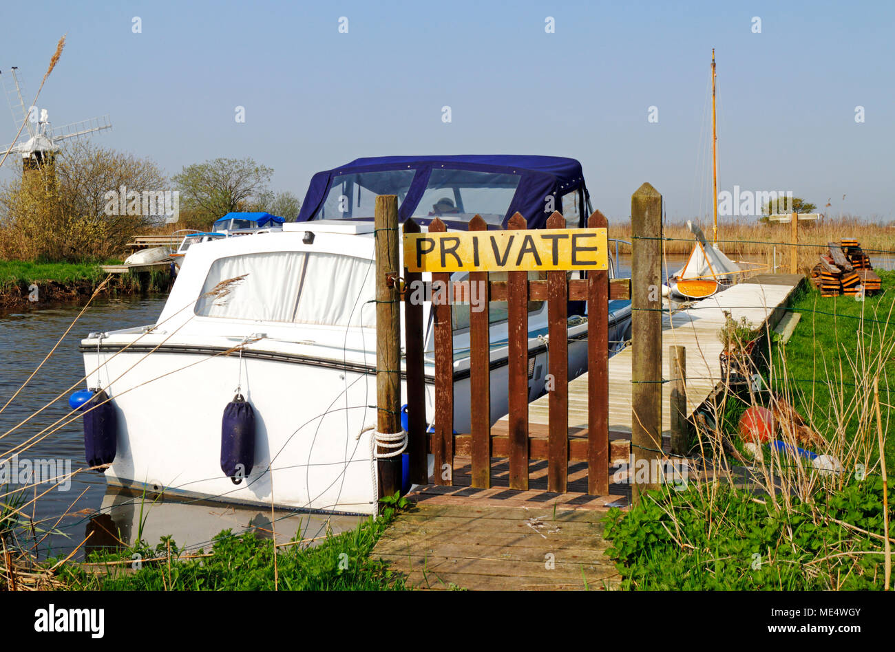 Una piccola diga con attracchi e segno privato dal fiume Thurne su Norfolk Broads a Thurne, Norfolk, Inghilterra, Regno Unito, Europa. Foto Stock