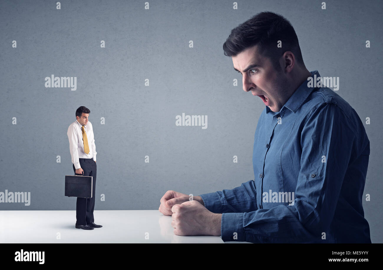 Giovane imprenditore professionale essendo arrabbiato con un altro imprenditore in miniatura Foto Stock